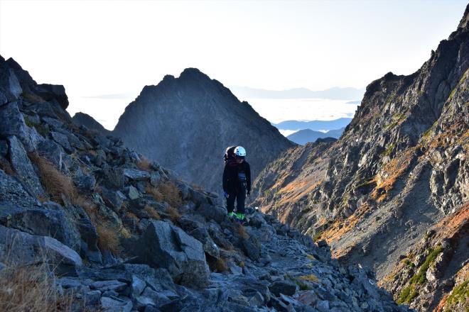 前穂高岳をバックに登って来る登山者