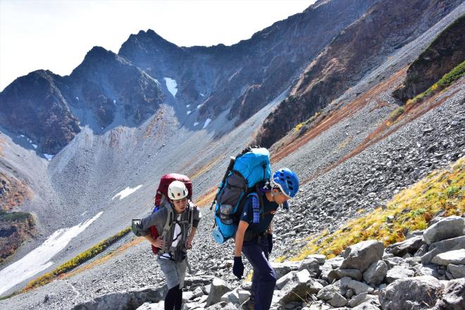 前穂高岳を背景に登る登山者